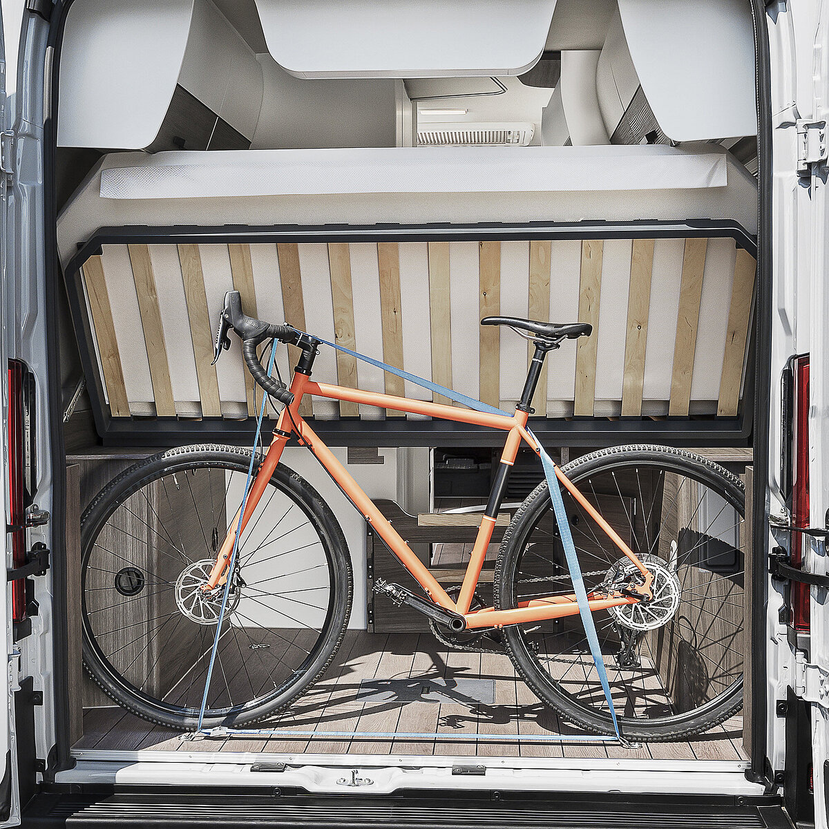 Heckstauraum im VANTourer Kastenwagen: Beladung mit einem Fahrrad unter dem hochgeklappten Festbett