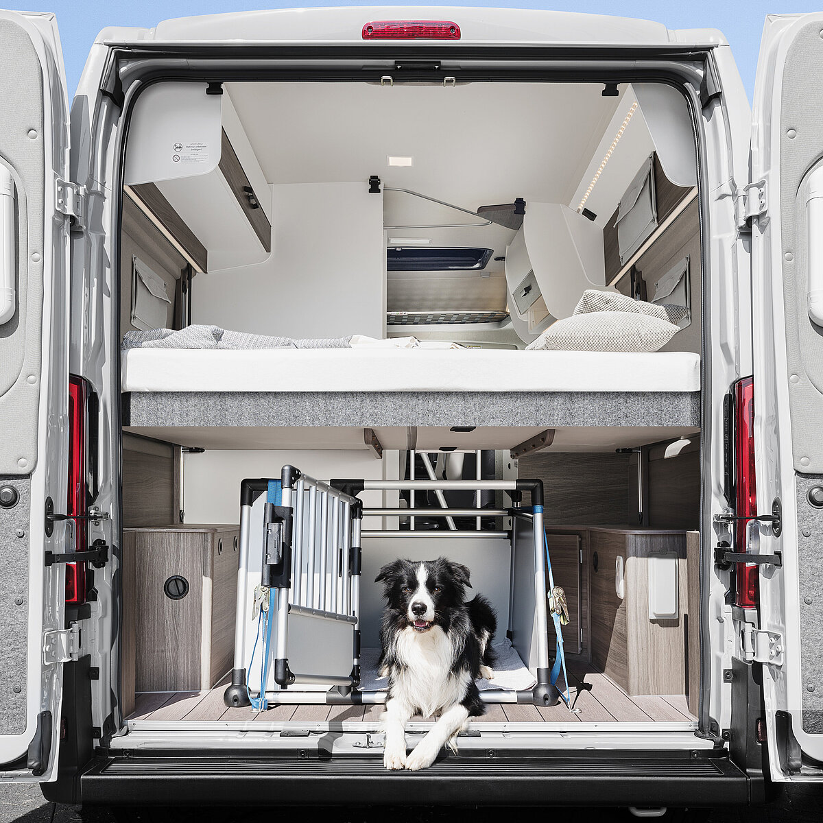 Heckstauraum im VANTourer Kastenwagen: Beladung mit einer Hundebox unter dem hochgefahrenen Hubbett