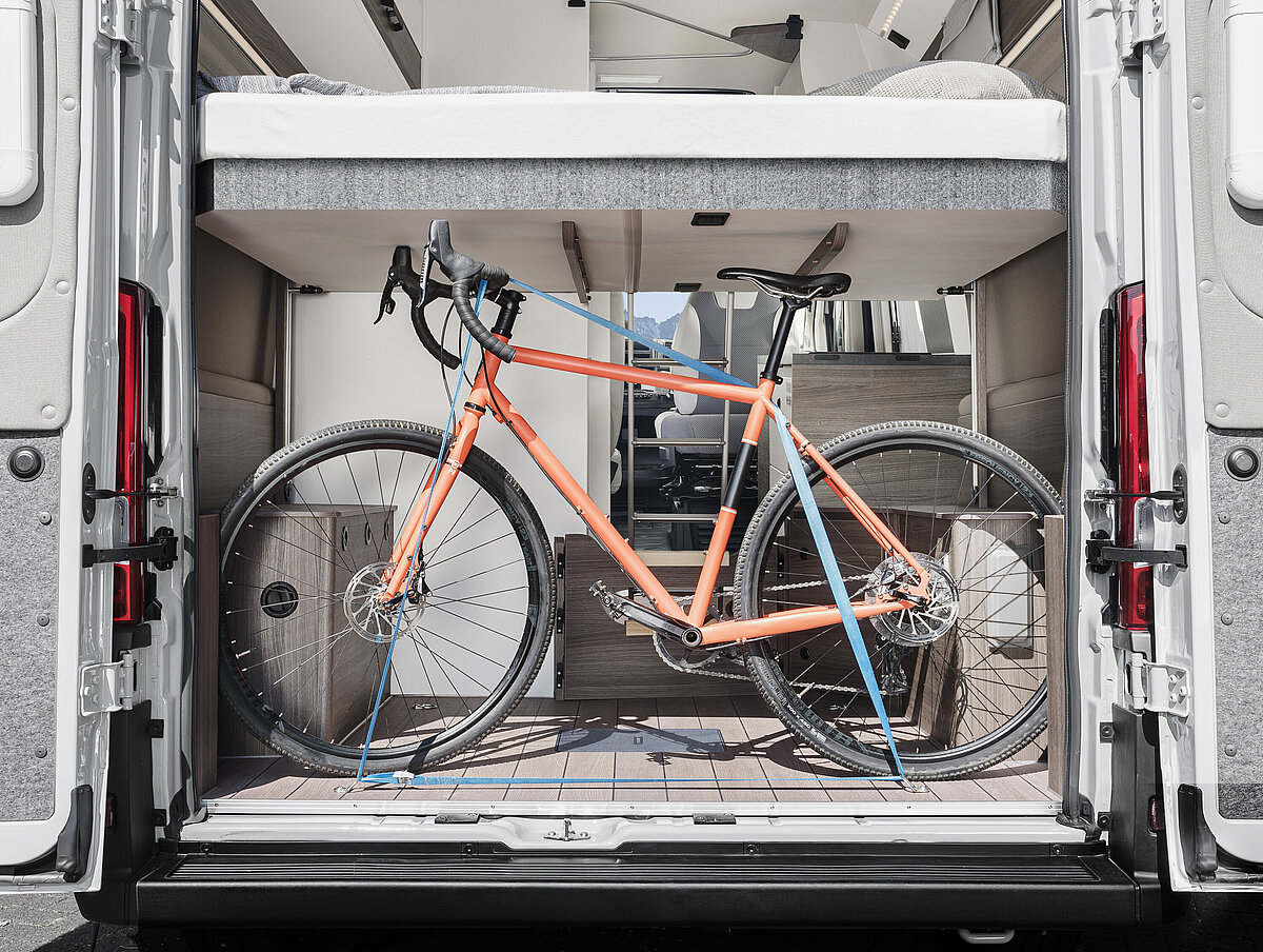 Transport eines Fahrrad unter dem Hubbett im Heckstauraum des VANTourer Campervans 540 D