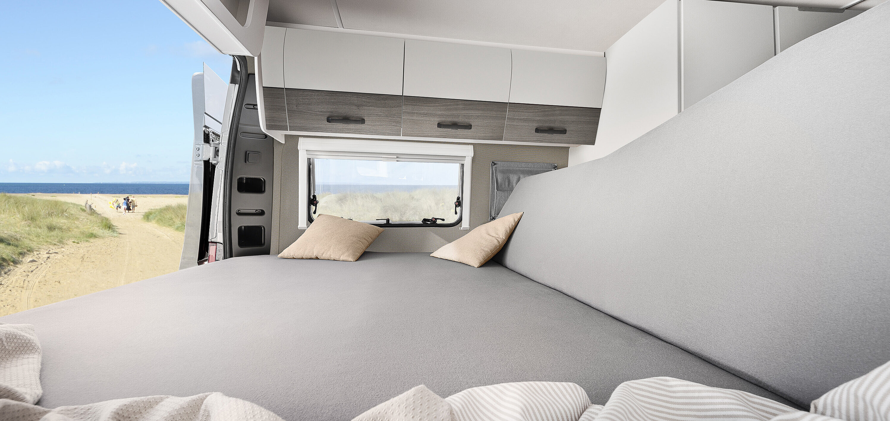 Bauen Sie im VANTourer Kastenwagen in wenigen Handgriffen das Bett zur gemütlichen Lounge mit Ausblick um